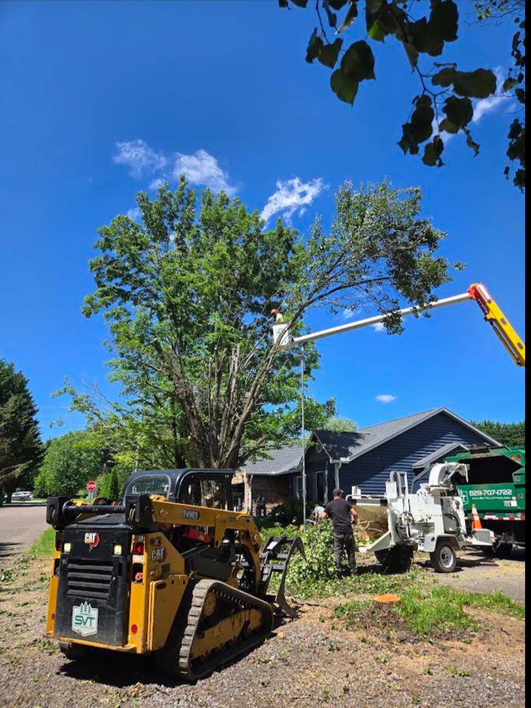 WNC Tree Experts crew with chipper, skid steer and bucket truck on a residential job in Arden, NC