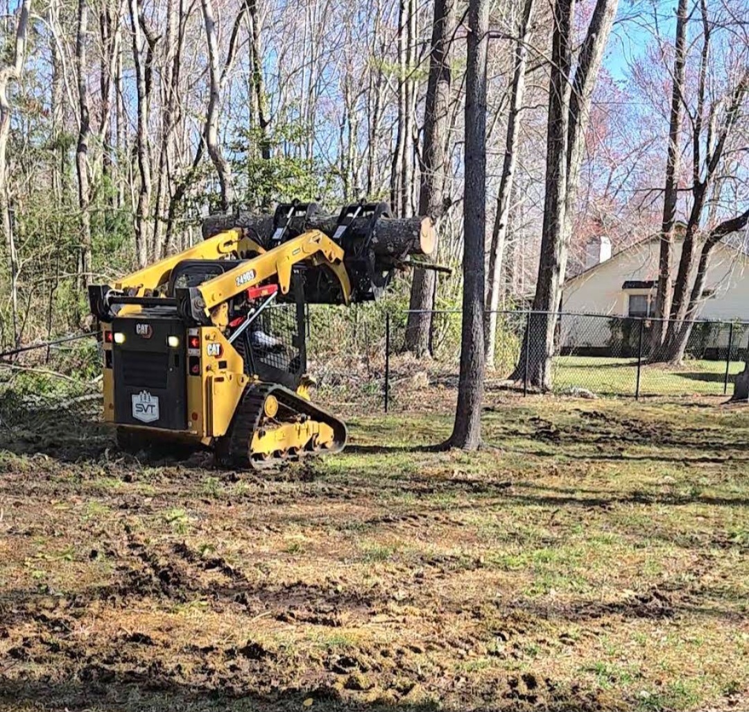Skid steer hauling logs during lot clearing and cleanup in Arden, NC